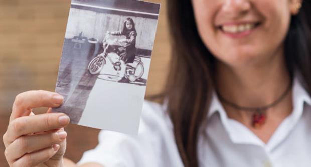 Imatge en què una dona ensenya la fotografia d'un nen