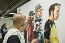 Detall de l'artista JupiterFab pintant els usuaris al mural / Miguel Ángel Cuartero